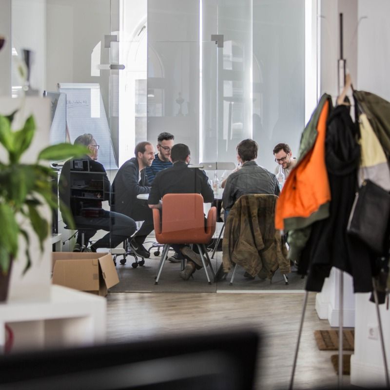 Team der Logic Joe Group bespricht sich im hellen Altbau-Büro