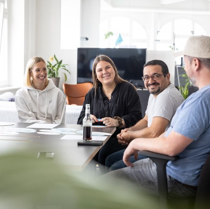 Kollegen der Logic Joe Group arbeiten gemeinsam am Tisch